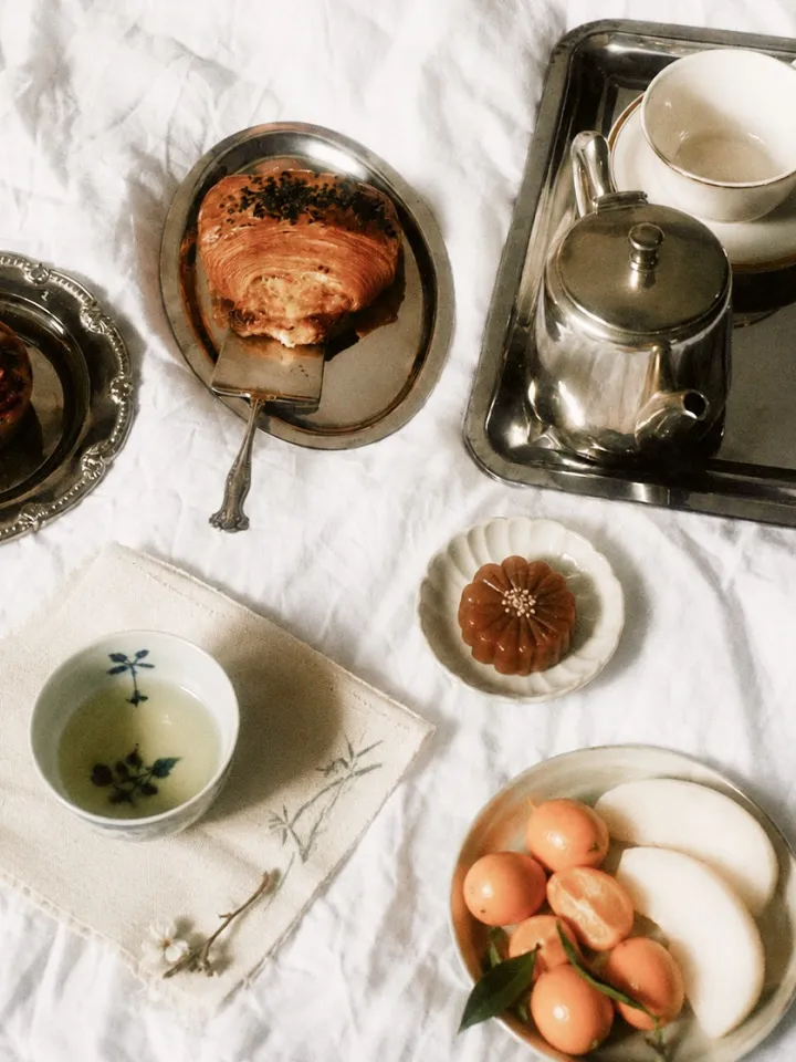 A slow morning table laid with tea, pastries, and fruit