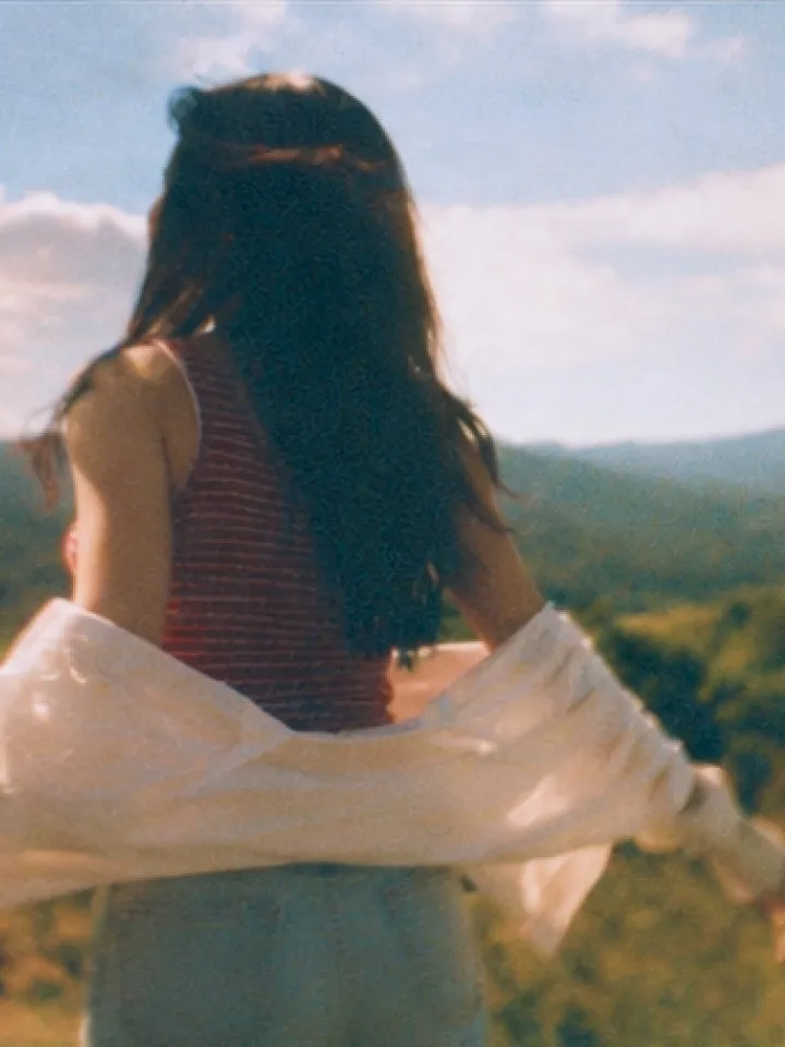 A traveler looking out over a range of distant mountains
